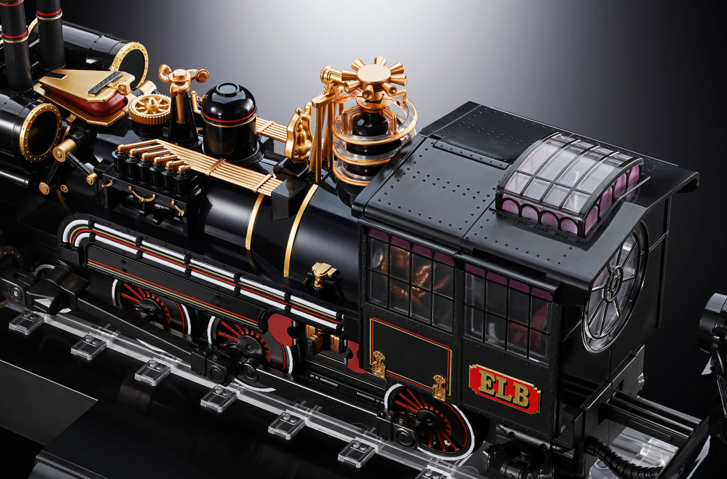 Detailed model of a black steam locomotive with gold and red accents on a dark background