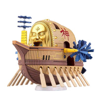 Bandai One Piece Ark Maxim model kit featuring a gold face, wooden hull, and blue propellers in a side-angle view.