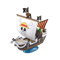 Bandai One Piece Grand Ship Collection Going Merry model kit with a white sail, ram figurehead, and blue display stand.