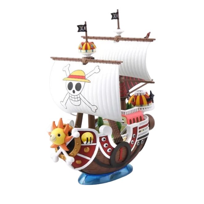 Bandai One Piece Thousand Sunny ship model kit with a lion figurehead, white sails, and pirate flags on a blue base.