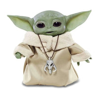 Front view of The Mandalorian The Child Animatronic Edition figure wearing a tan robe with a Mythosaur pendant.