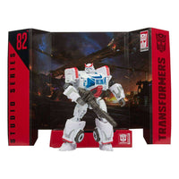 Hasbro Transformers Studio Series Autobot Ratchet action figure in white and red armor, posed with a blaster in packaging.