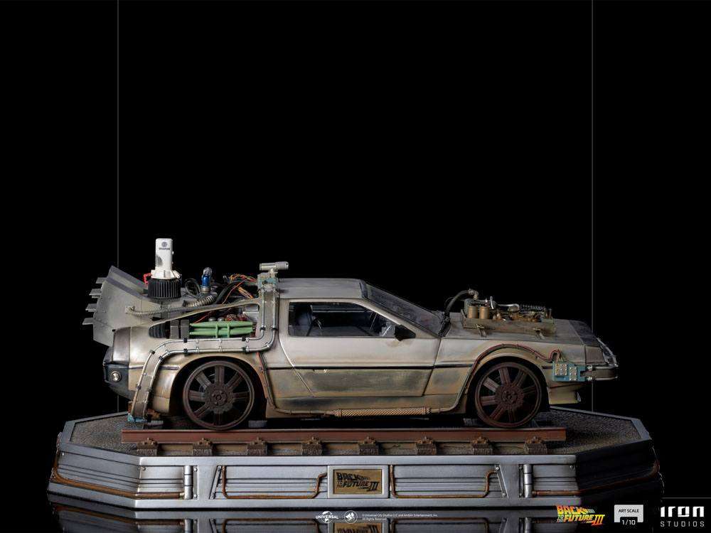Side view of the Iron Studios 1/10 scale Back to the Future III DeLorean statue on a weathered train track base.