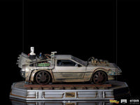 Side view of the Iron Studios 1/10 scale Back to the Future III DeLorean statue on a weathered train track base.