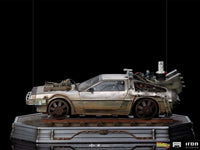 Side view of the Iron Studios 1/10 scale Back to the Future III DeLorean statue on a weathered train track base.