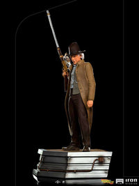 Iron Studios 1/10 Doc Brown statue from Back to the Future III, featuring the character holding a rifle on a base.