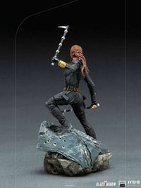 Rear view of Iron Studios Black Widow 1/10 scale statue in a black tactical suit, wielding batons on a rocky base.