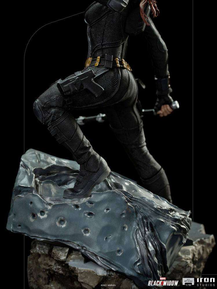 Side view of Iron Studios Black Widow 1/10 scale statue in a black tactical suit standing on a rocky, cratered base.