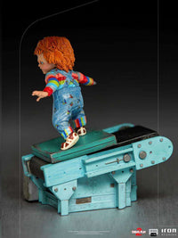 Side view of the 15cm Iron Studios Child's Play 2 Chucky statue standing on a weathered blue factory conveyor belt.