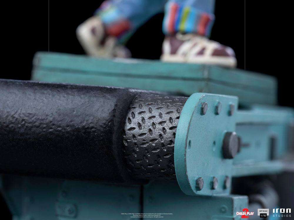 Close-up of the Iron Studios Child's Play 2 Chucky 1/10 statue base, featuring a textured black and teal conveyor belt.