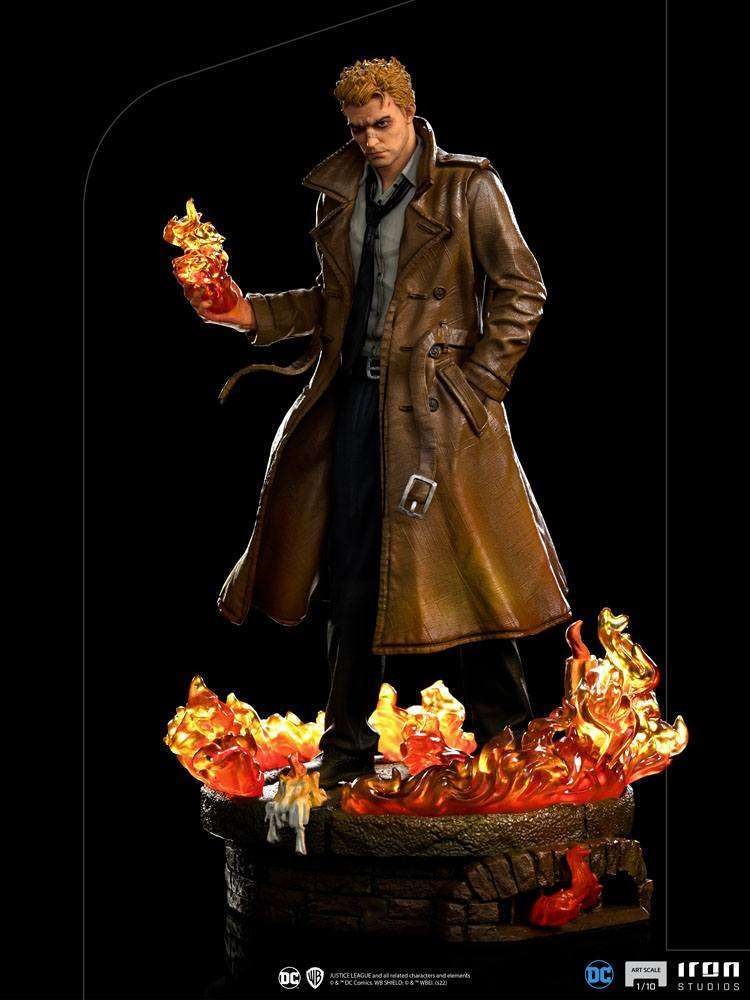 Iron Studios 1/10 Constantine statue in a brown trench coat, holding magical fire over a burning brick base.