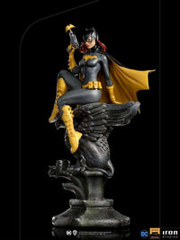Iron Studios 1/10 Batgirl Deluxe Art Scale statue in a side view, featuring a dark suit, yellow cape, and bat-signal gun.