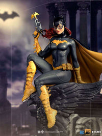 Iron Studios 1/10 Batgirl Deluxe Art Scale statue featuring the hero in a black and gold suit, perched on a stone gargoyle.