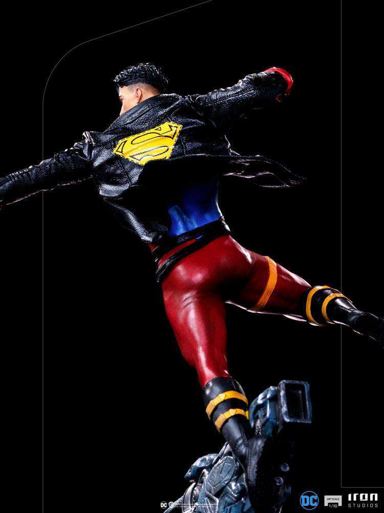Rear view of Iron Studios 1/10 Superboy statue wearing a black leather jacket with yellow Superman logo on a base.