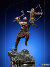 Iron Studios 1/10 Kratos & Atreus statue showing Kratos wielding his axe while Atreus aims his bow on a stone base.