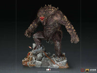 Iron Studios God of War 1/10 Ogre statue in a dynamic pose, featuring textured dark skin and a rocky, detailed base.