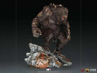 Side view of the 32 cm Iron Studios God of War Ogre 1/10 scale statue featuring a textured brown monster on a snowy base.