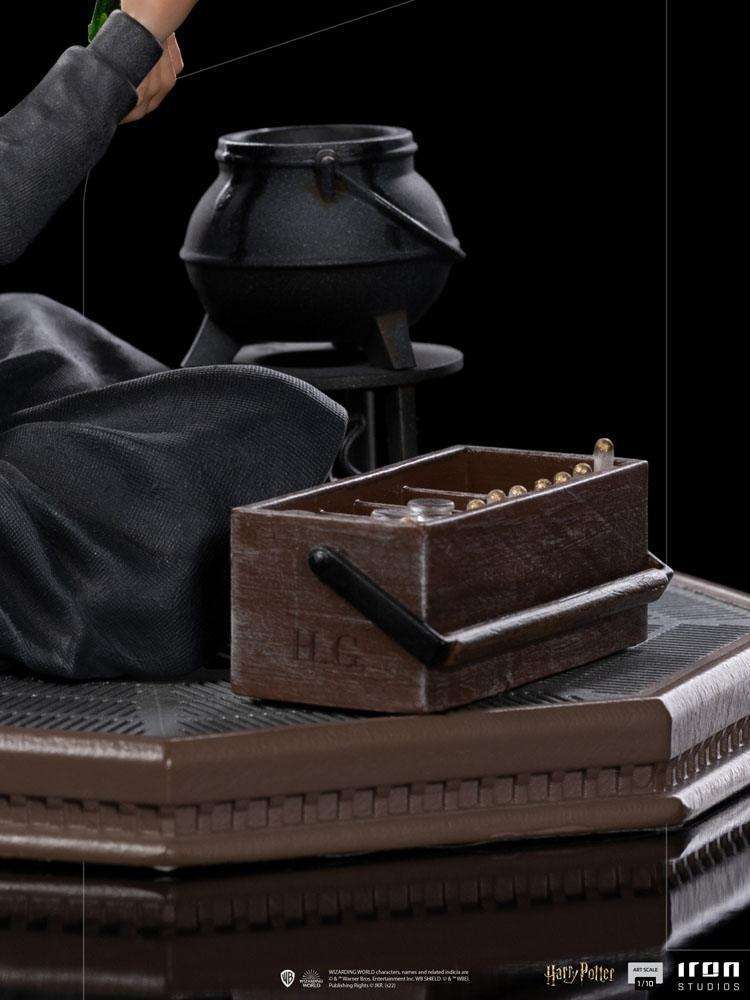 Close-up of Iron Studios Hermione Granger Polyjuice 1/10 statue showing a black cauldron and wooden potion kit on base.