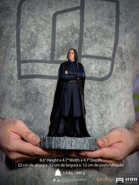 Front view of a 22 cm Iron Studios Severus Snape 1/10 scale statue wearing a black cloak, held in two hands.