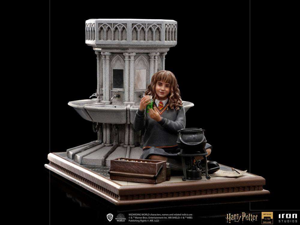Iron Studios 1/10 Hermione Granger Polyjuice statue showing her holding a green potion by a stone fountain base.