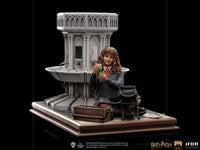 Iron Studios 1/10 Hermione Granger Polyjuice statue showing her holding a green potion by a stone fountain base.