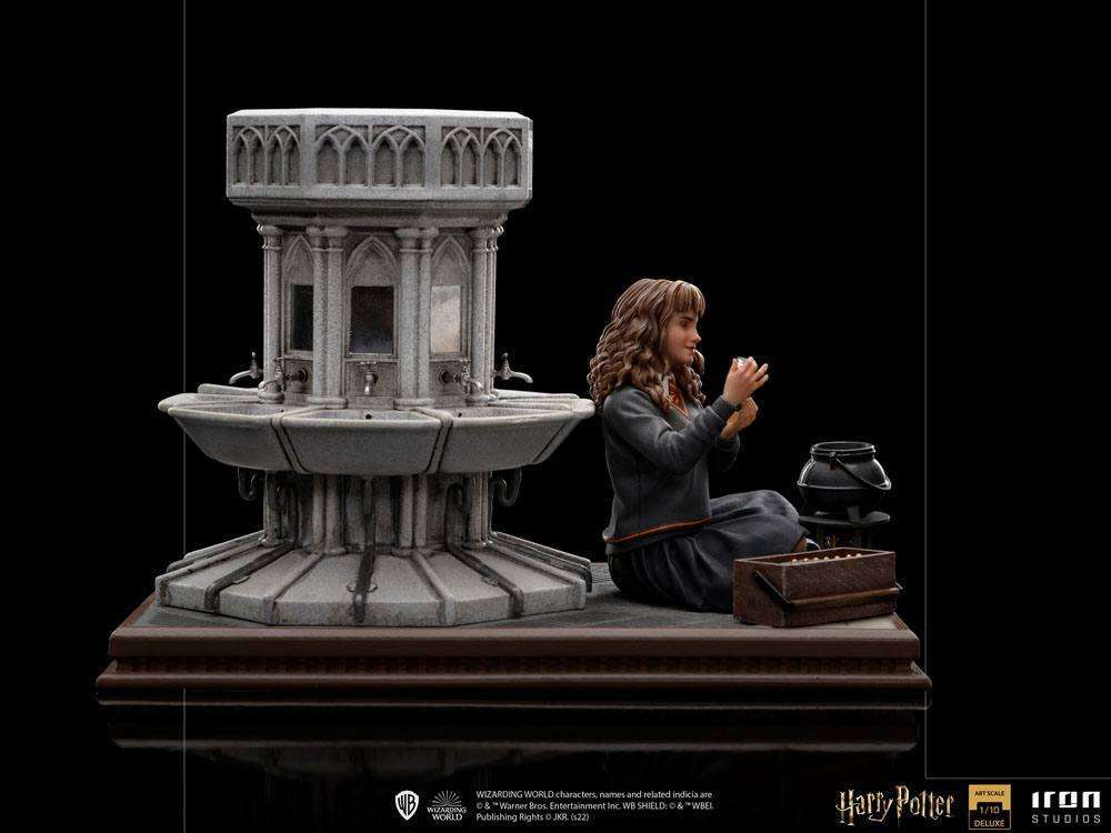 Iron Studios Hermione Granger Polyjuice 1/10 scale statue sitting beside a stone fountain in a side-view display.