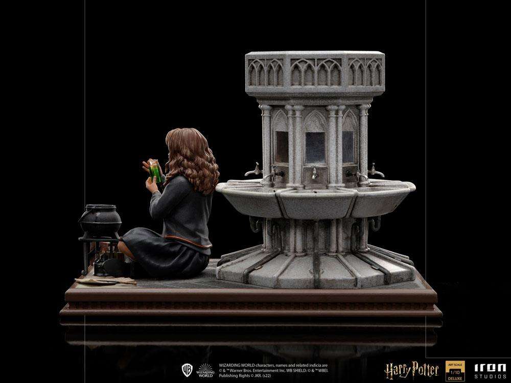 Side view of Iron Studios Hermione Granger Polyjuice 1/10 scale statue sitting by a stone fountain with a potion vial.