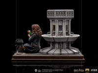 Side view of Iron Studios Hermione Granger Polyjuice 1/10 scale statue sitting by a stone fountain with a potion vial.