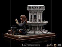 Side view of Iron Studios Hermione Granger Polyjuice 1/10 scale statue sitting by a stone fountain with a potion vial.