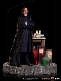Iron Studios 1/10 scale Severus Snape statue in a black robe, standing on a stone base with potion bottles and a desk.