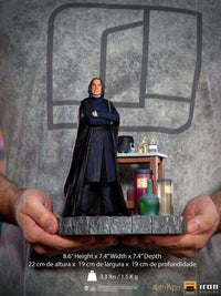 Iron Studios 1/10 scale Severus Snape statue in black robes, held in hands with a potion-filled desk base.