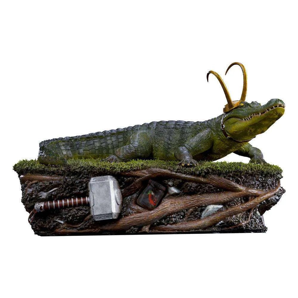 Iron Studios Alligator Loki 1/10 scale statue featuring a detailed green alligator with golden horns on a root base.