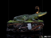 Side view of the 15cm Iron Studios Alligator Loki 1/10 scale statue wearing a golden horned helmet on a mossy base.