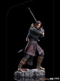 Iron Studios 1/10 scale Aragorn statue in a dynamic combat pose with sword, wearing detailed ranger gear on a rock base.