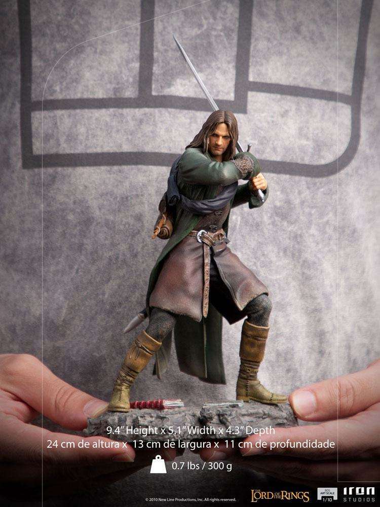 Iron Studios 1/10 scale Aragorn statue in a dynamic combat pose with sword, wearing a green cloak and leather gear.