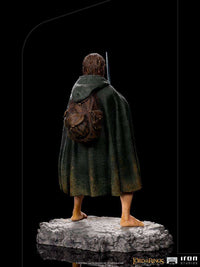 Back view of Iron Studios 1/10 Frodo statue featuring a textured green cloak, detailed brown backpack, and rocky base.
