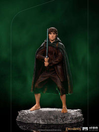 Iron Studios 1/10 scale Frodo statue standing on a rocky base, holding Sting sword, wearing a brown suit and dark cloak.