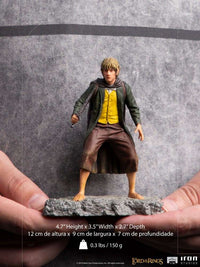 Front view of the 12 cm Iron Studios Merry BDS Art Scale statue wearing a green coat and yellow vest on a rocky base.