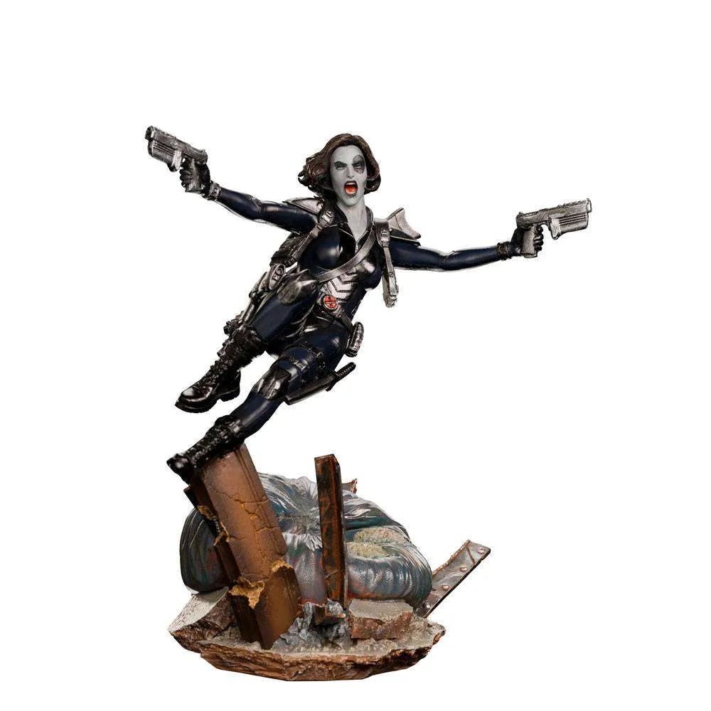 Iron Studios 1/10 Domino statue in a dynamic leaping pose, wearing a black tactical suit and dual-wielding pistols.