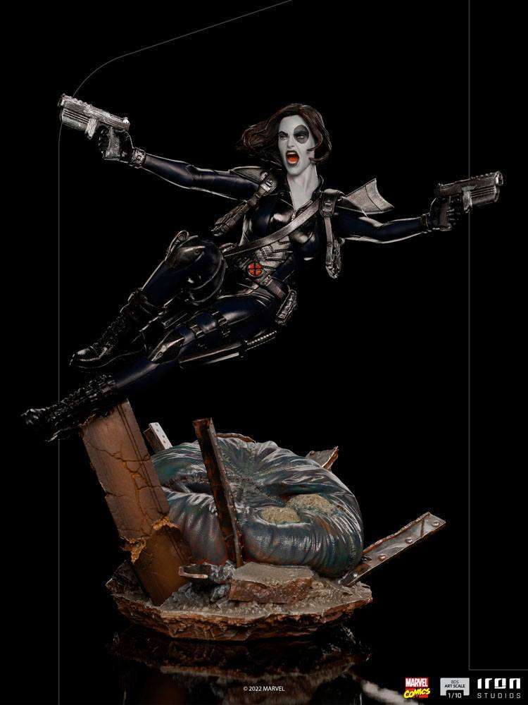 Iron Studios 1/10 scale Domino statue in a dynamic leaping pose with dual pistols on a detailed rubble base.