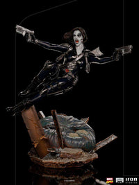 Iron Studios 1/10 scale Domino statue in a dynamic leaping pose with dual pistols on a detailed rubble base.