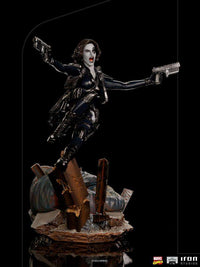 Iron Studios 1/10 scale Domino statue in a dynamic action pose, featuring a black bodysuit and dual pistols on a base.