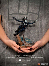 Iron Studios 1/10 scale Domino statue in a dynamic pose with dual pistols, held in hands for size reference.