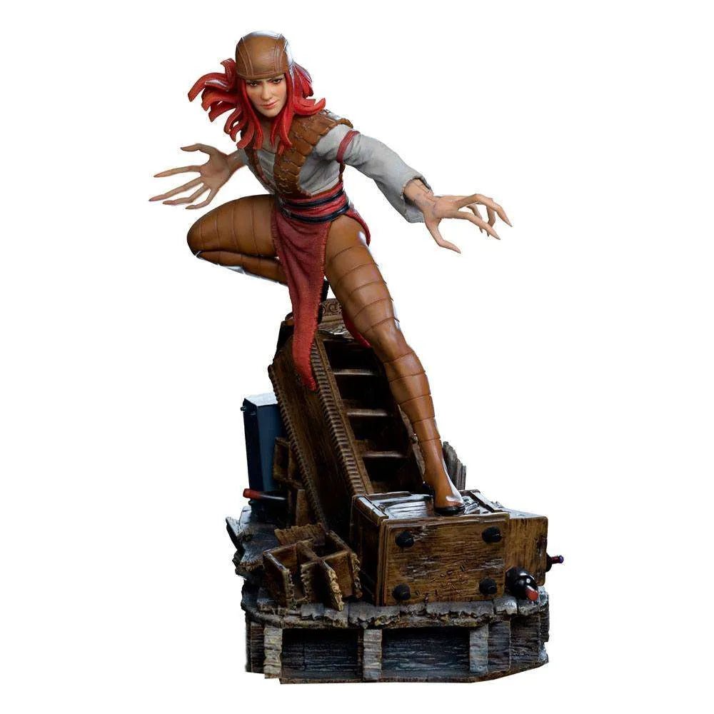 Iron Studios Lady Deathstrike 1/10 scale statue featuring red hair, brown armor, and long claws on a wooden base.