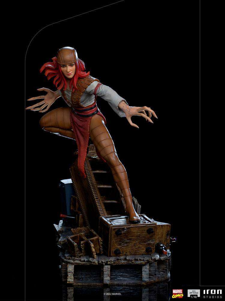 Iron Studios Lady Deathstrike 1/10 scale statue featuring red hair and long claws, posed dynamically on a wooden base.
