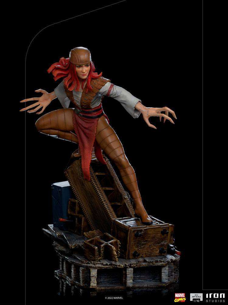 Iron Studios Lady Deathstrike 1/10 scale statue featuring red hair, brown armor, and long claws on a debris base.