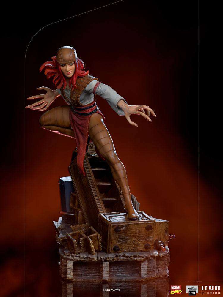 Iron Studios 1/10 Lady Deathstrike statue featuring red hair, brown armor, and long claws on a wooden base, front view.