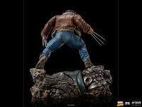 Back view of Iron Studios 1/10 Logan statue wearing a brown leather jacket and blue jeans standing on a rocky base.