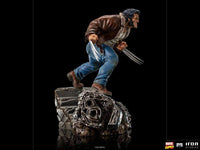 Side view of Iron Studios 1/10 Logan statue wearing a brown leather jacket and jeans with extended metal claws.