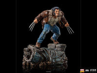 Iron Studios 1/10 Logan statue showing Wolverine in a brown leather jacket and jeans with claws extended on a base.